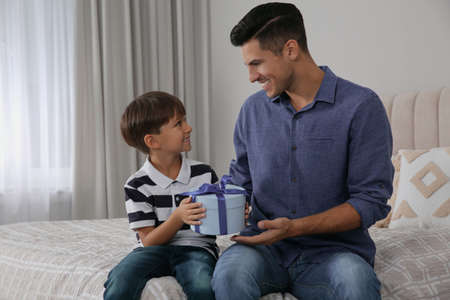 Man receiving gift for Father's Day from his son at homeの写真素材