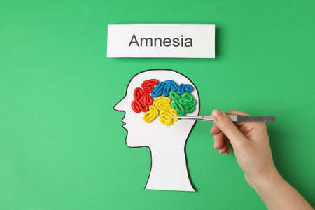 Woman making brain model with colorful plasticine on green background, top view. Amnesia conceptの写真素材