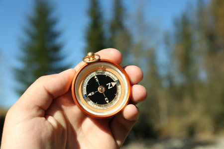 Man using compass for navigation during journey outdoors, closeupの写真素材