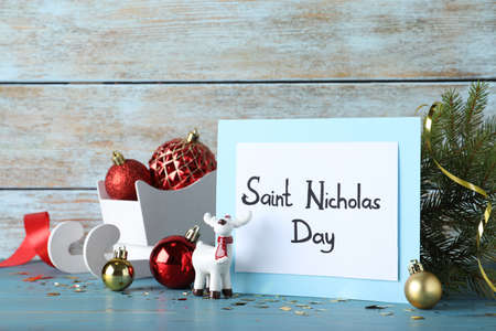 Card with text Saint Nicholas Day and festive decor on light blue wooden tableの写真素材
