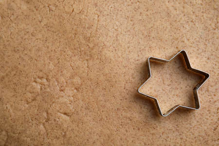 Homemade Christmas biscuits. Cookie cutter on raw dough, top viewの写真素材
