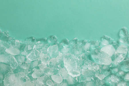 Pile of crushed ice on turquoise background, top view. Space for textの写真素材