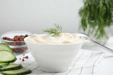 Tasty creamy dill sauce in bowl on white kitchen towel, closeupの写真素材