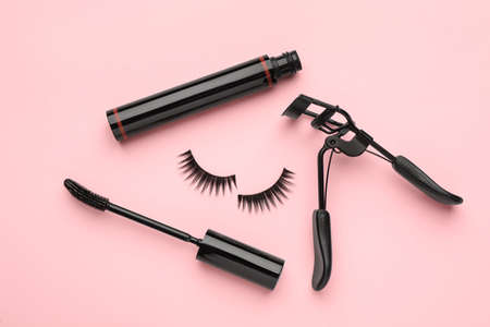 False eyelashes, curler and mascara on pink background, flat layの写真素材