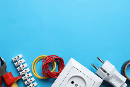 Set of electrician's tools and accessories on light blue background, flat lay. Space for textの写真素材