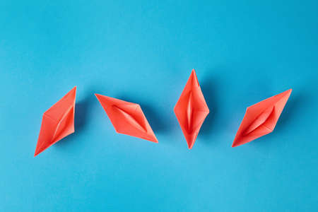 Handmade pink paper boats on light blue background, flat lay. Origami artの写真素材