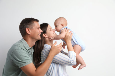 Portrait of happy family with their cute baby on white background