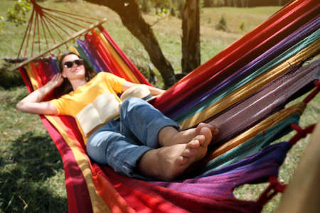 Woman resting in hammock outdoors, focus on legsの写真素材