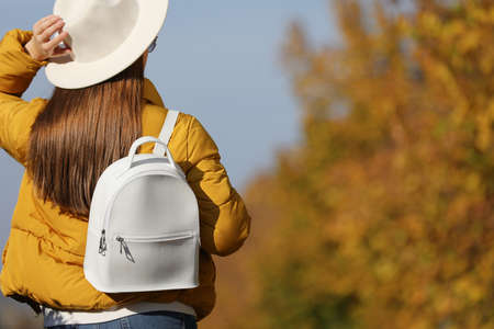 Young woman with stylish backpack on autumn day, back view. Space for textの写真素材