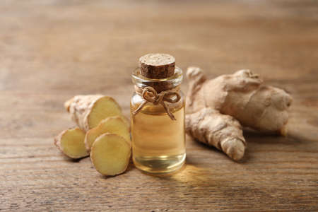 Ginger essential oil in bottle on wooden tableの写真素材