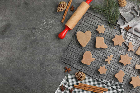 Homemade Christmas cookies. Flat lay composition with raw gingerbread biscuits on gray table, space...