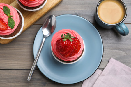 Sweet cupcake with fresh strawberry served on wooden table, flat layの写真素材