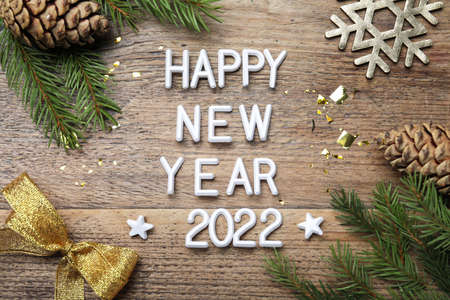 Flat lay composition with phrase Happy New Year 2022 and festive decor on wooden backgroundの写真素材