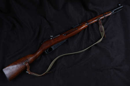 Vintage hunting gun on dark fabric, top view