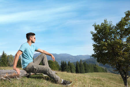 Man enjoying beautiful mountain landscape on sunny dayの写真素材