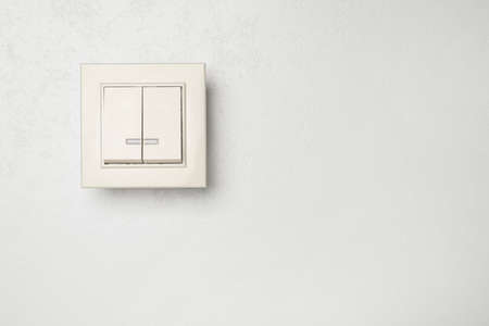 Modern light switch on white background. Space for text