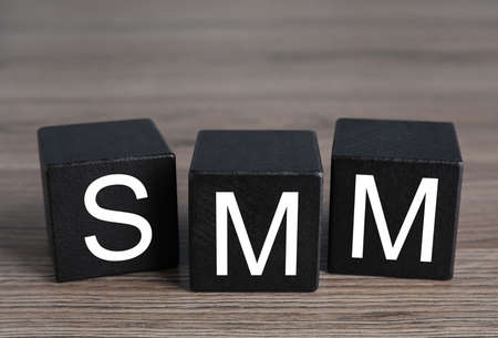 Cubes with abbreviation SMM (Social media marketing) on wooden tableの写真素材