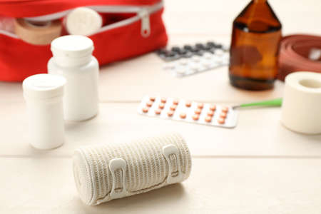 Bandage and pills on white wooden table, closeup. First aid kitの写真素材