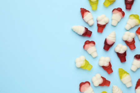 Tasty jelly candies in shape of ice cream on light blue background, flat lay. Space for textの写真素材