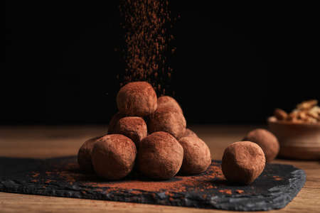 Tasty chocolate truffles powdered with cacao on slate boardの写真素材