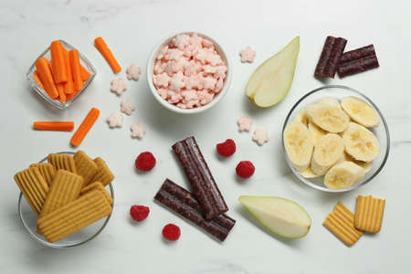 Set of different finger foods for baby on white marble table, flat layの写真素材