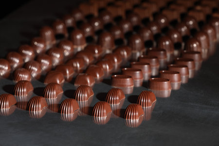 Many delicious chocolate candies on table. Production line