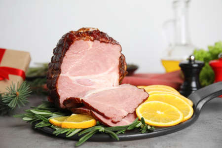 Delicious ham served with orange and rosemary on gray table. Christmas dinnerの写真素材