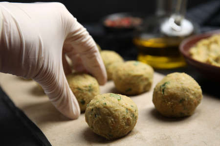 Cook making falafel balls at black table, closeupの写真素材