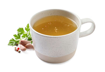 Hot delicious bouillon in cup and ingredients on white backgroundの写真素材