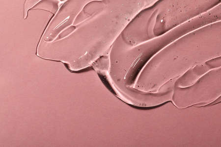 Transparent cosmetic gel on pink background, space for text