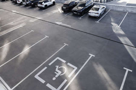 Car parking lot with white marking lines and wheelchair symbol outdoors, above viewの写真素材