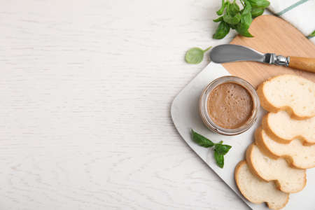 Delicious meat pate, fresh bread, knife and basil on white wooden table, flat lay. Space for textの写真素材