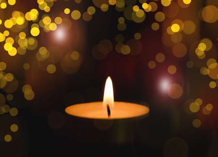Wax candle burning in darkness, bokeh effect. Christmas eveの写真素材