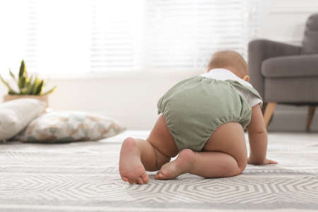 Cute baby crawling at home, focus on legsの写真素材