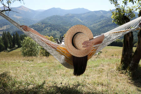 Young woman resting in hammock outdoors on sunny dayの写真素材