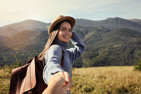Young woman with her boyfriend in mountains on sunny dayの写真素材
