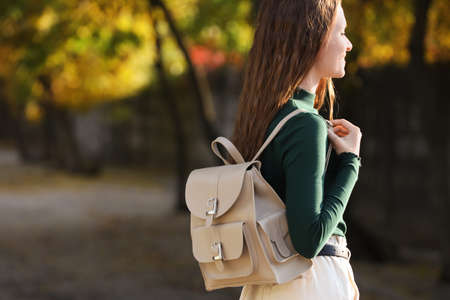 Young woman with stylish beige backpack on city street, space for textの写真素材