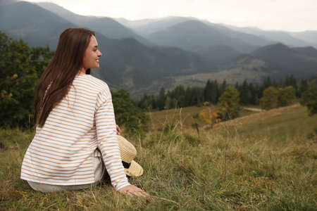 Young woman enjoying beautiful mountain landscape. Space for textの写真素材