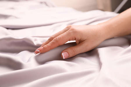 Woman touching smooth silky fabric indoors, closeupの写真素材