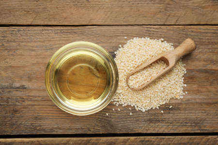 Fresh sesame oil and seeds on wooden table, flat layの写真素材