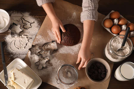 Little child making Christmas cookies at wooden table, top viewの写真素材