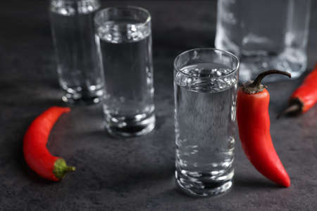 Red hot chili peppers and vodka on gray tableの写真素材