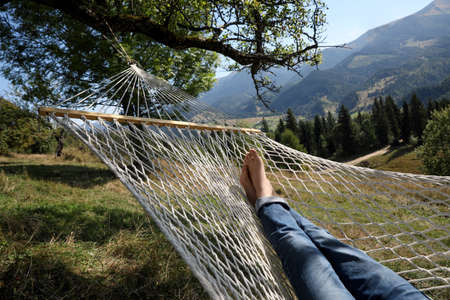 Man resting in hammock outdoors on sunny day, closeupの写真素材