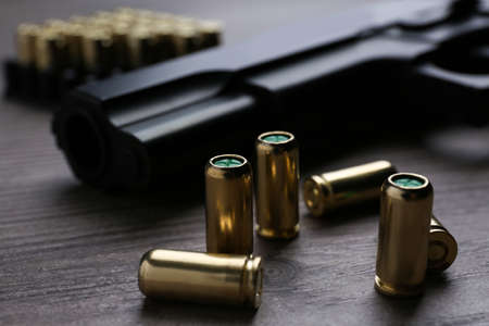 Pistol bullets on wooden table, closeup. Professional gunの写真素材
