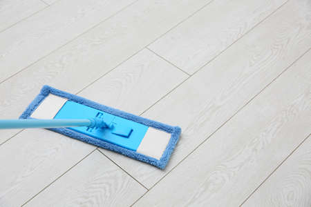 Washing of parquet floor with mop. Space for text