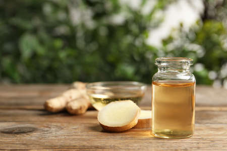 Ginger essential oil in bottle on wooden table. Space for textの写真素材