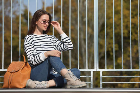 Young woman with stylish backpack on autumn dayの写真素材