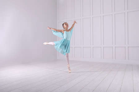 Beautifully dressed little ballerina dancing in studio. Space for textの写真素材