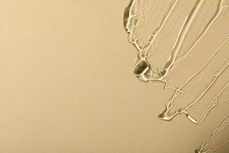 Transparent cosmetic gel on beige background, top view. Space for text
