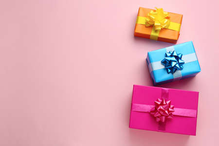 Bright gift boxes on pink background, flat lay. Space for textの写真素材